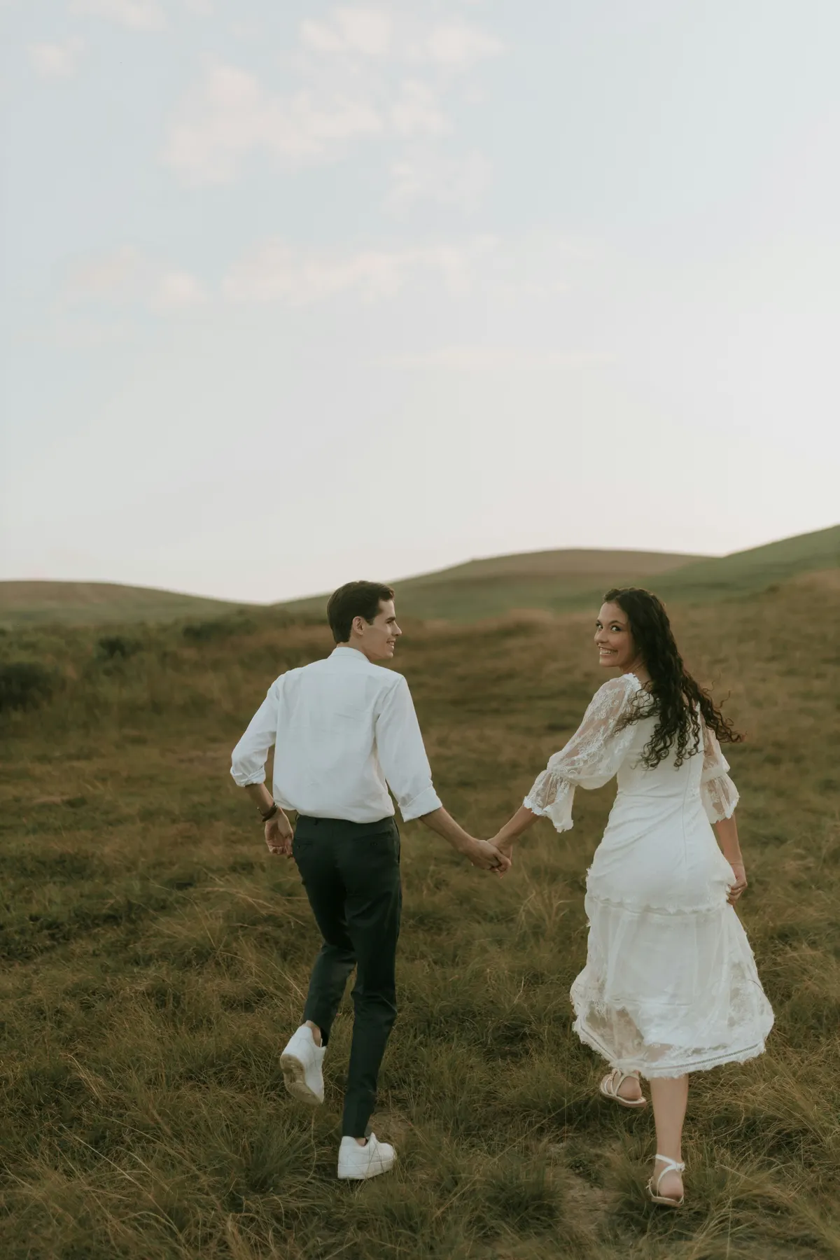 Oliver und Marie laufen Hand in Hand durch die Wiese